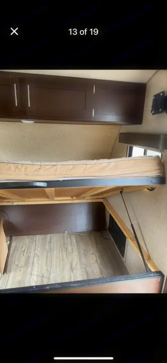 RV rental bedroom: Bed lifts for spacious under-bed storage. Features overhead cabinets & wood-look floor.. Forest River Cherokee Wolf Pup Cascade 2017