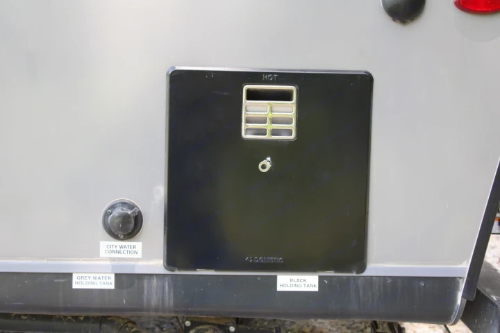RV rental exterior: water heater access, city water connection, and grey/black holding tank labels. Essential utility features.. Jayco Jay Flight 2022