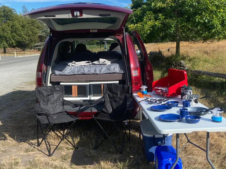 Minivan **RV rental** ready for adventure: tailgate open to a bed, plus an outdoor camp kitchen with all the gear.. Dodge Grand Caravan 2010