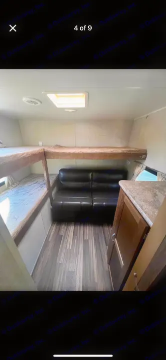 RV rental interior: L-shaped bunk beds, a sofa, and wood flooring create a functional and cozy living space.. Gulf Stream Conquest 2017