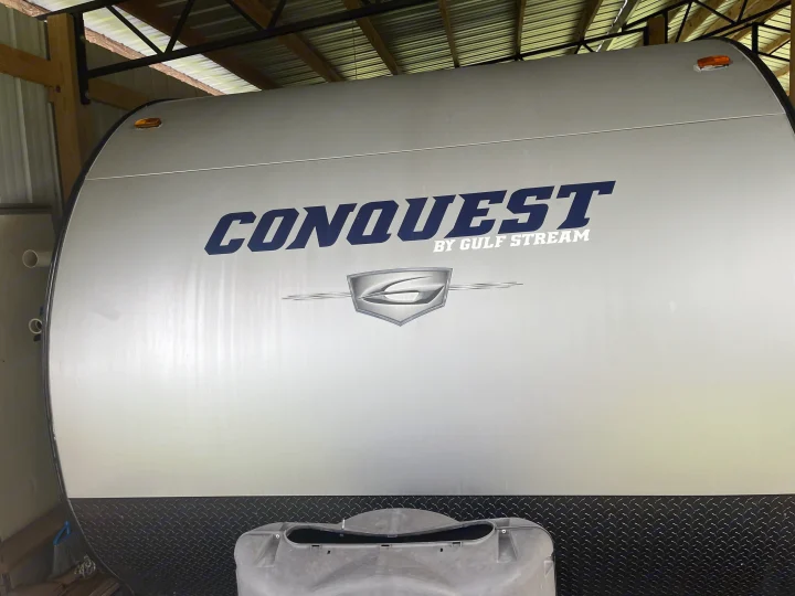 Front of a silver "Conquest by Gulf Stream" travel trailer, perfect for your next RV rental adventure.. Gulf Stream Conquest 2017