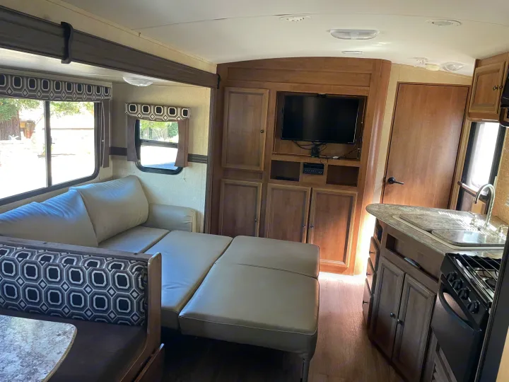Spacious RV rental interior with convertible sofa bed, dinette, and kitchen for comfortable travel adventures.. Cruiser RV Radiance 2015