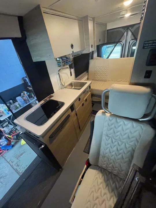 This modern RV rental features a well-equipped kitchenette with sink and cooktop, stylish quilted seating, and intelligent storage design.. Winnebago Winnebago Solis P 2022