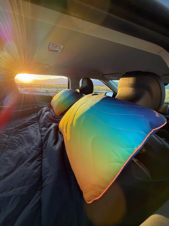 Cozy car camping setup with sunset views through the back window, perfect for your next road trip or rv rental adventure.. Kia EV6 Wind All Wheel Drive 2022
