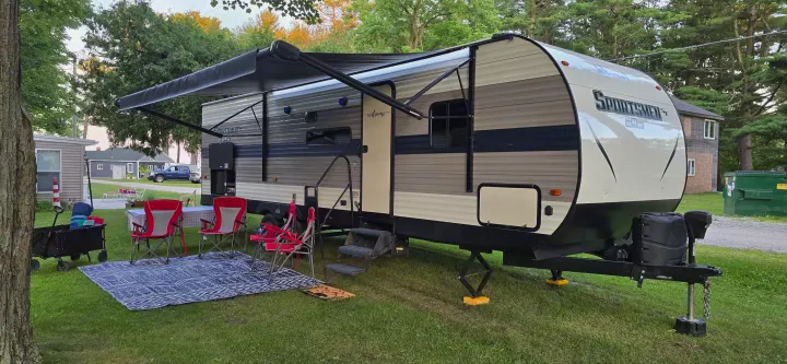 Enjoying the outdoors! This rv rental is set up for a perfect camping trip, featuring an extended awning, chairs, and an outdoor mat.. KZ 301BHKSE 2021