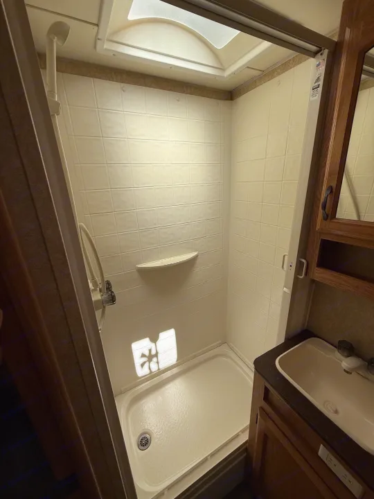 RV rental with a functional bathroom: compact shower stall with skylight, sink, and vanity.. Denali Denali Trailer 2011