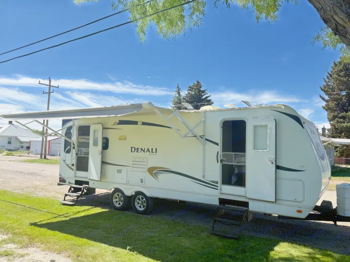 RV rental: White Denali travel trailer with extended awning & open doors, ready for outdoor adventures.. Denali Denali Trailer 2011