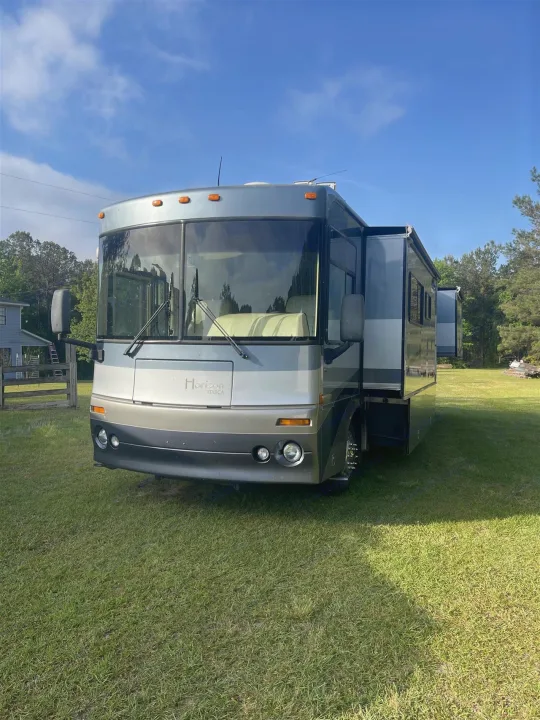 Spacious Horizon Itasca RV rental parked on a sunny green field, ready for your next outdoor adventure.. Itasca Horizon 2002