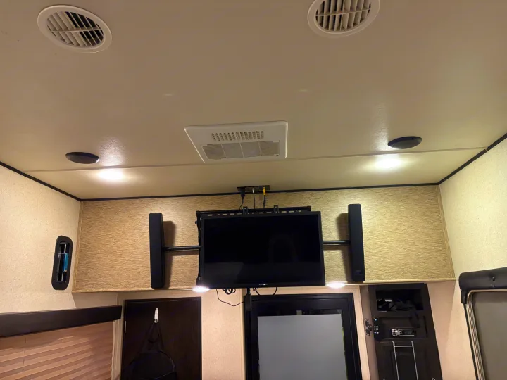 RV rental interior featuring a mounted TV, speakers, AC, and lighting. Ideal for entertainment on the road.. Grand Design Momentum Toy Hauler 2015
