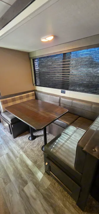RV rental dinette with cozy bench seating, wooden table, and window blinds.. Grand Design Transcend Xplor 2021
