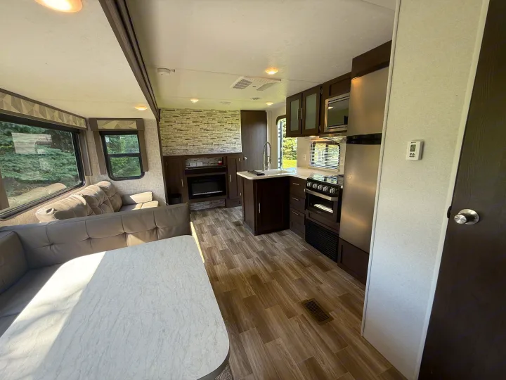 Inside a modern RV rental: cozy living space with dinette, fully equipped kitchen, and fireplace.. Forest River Salem 2019