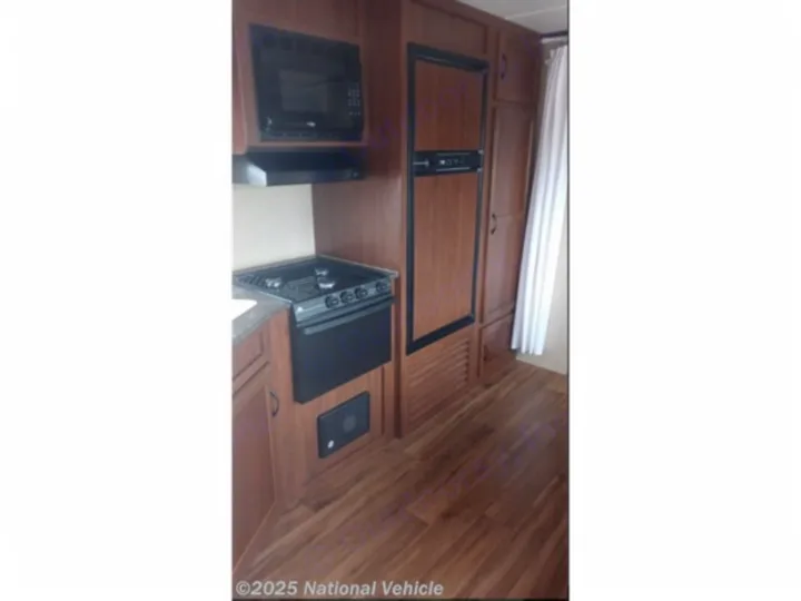 RV rental camper kitchen: microwave, stovetop, oven, and fridge. Perfect for road trip cooking.. Jayco Jay Flight SLX 2016