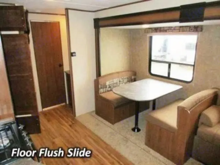 RV rental interior with a spacious dinette, large window, and "floor flush slide-out" for extra room.. Jayco Jay Flight SLX 2016