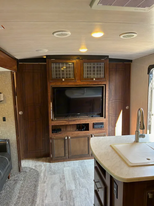 An RV rental's well-appointed interior features an entertainment center, ample storage, and a kitchen island with sink.. Heartland RVs Mallard 2019