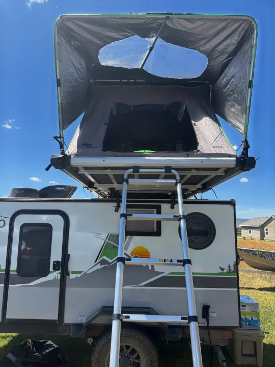 This RV rental features a deployed rooftop tent, accessed by a ladder, ready for your outdoor adventures.. Forest River Nobo 10.7 2024