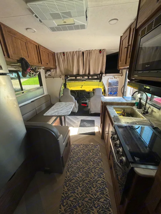 Spacious RV rental interior features a well-equipped kitchen, comfy dinette, and driver's cabin for your road trip.. 1FDWE3FNXSDD14715 Cross trail 22xgf 2025