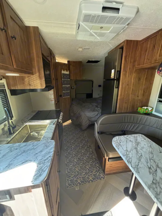 Bright rv rental interior featuring a modern kitchen, spacious dinette, and a private, cozy bedroom.. 1FDWE3FNXSDD14715 Cross trail 22xgf 2025