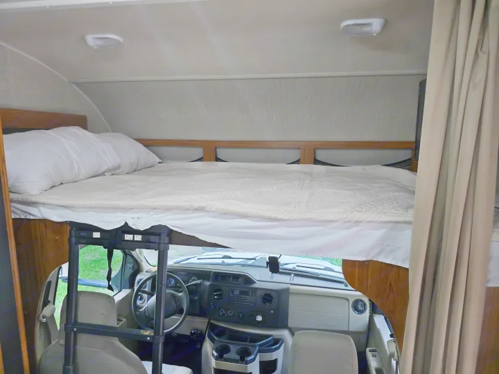 RV rental: View inside a comfortable RV showing a large cabover bed and the vehicle's cockpit. Ready for travel!. Jayco Redhawk 2017
