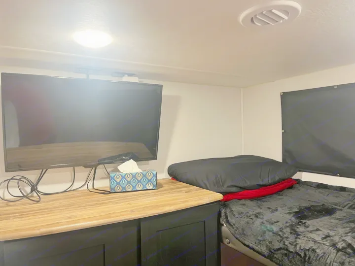 Cozy RV rental bedroom with TV, comfortable bed, and a compact setup for travel convenience.. Coachmen 29SE 2022