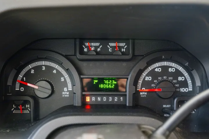 Dashboard of an RV rental showing low fuel, 18066.2 miles on the odometer, and gear selector in Park. Speedometer and tachometer are at zero.. Forest River Sunseeker 2015