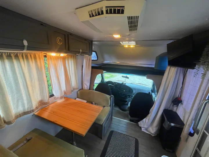 Cozy RV rental interior showcasing a dinette, overhead bunk, and front cabin view. A spacious home away from home.. Gulf Stream Ultra 1998