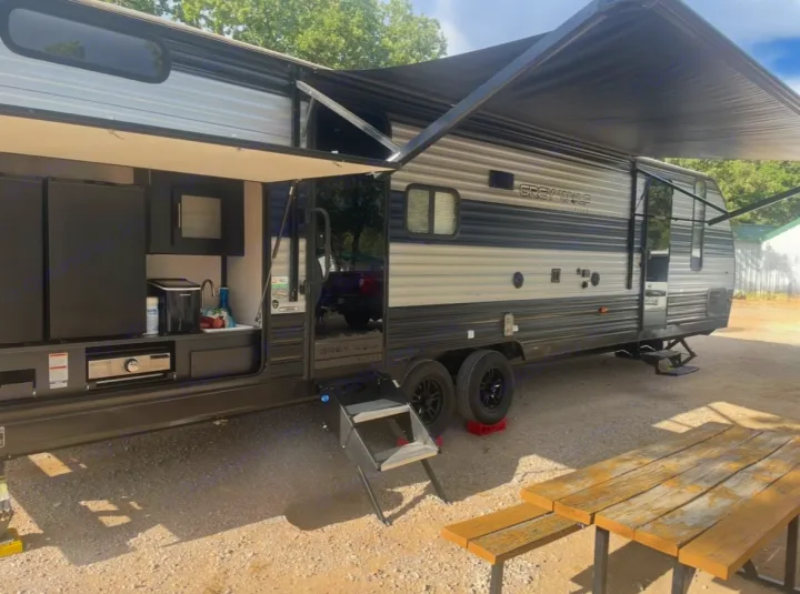 This RV rental features an outdoor kitchen & extended awning, perfect for campsite living.. Forest River Cherokee Grey Wolf 2022