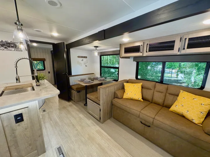 Cozy RV rental interior with a modern kitchen, dining booth, and comfortable sofa. Perfect for road trip adventures.. Forest River Puma 2026