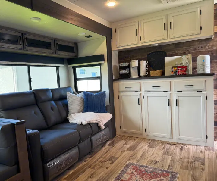 Step into comfort! This rv rental features a cozy living space with recliners, a coffee station, and wood-look floors.. SportTrek Venture 2024
