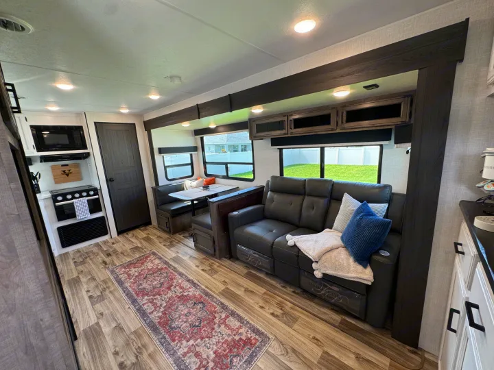 Spacious RV rental interior with comfy recliners, a dinette, and a full kitchen. Perfect for your next road trip adventure!. SportTrek Venture 2024