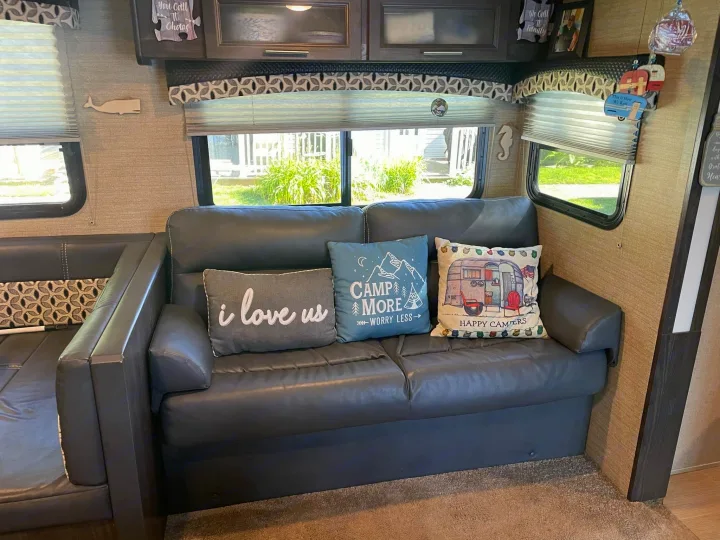 Cozy RV rental interior with a comfy sofa, decorative pillows, and scenic windows, perfect for a road trip adventure.. Dutchmen Kodiak Ultra-Light 2018