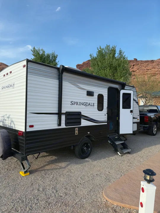 Enjoying our RV rental! This Springdale Mini travel trailer is parked on gravel, ready for adventures amidst red rock mountains.. Keystone RV Springdale 2022