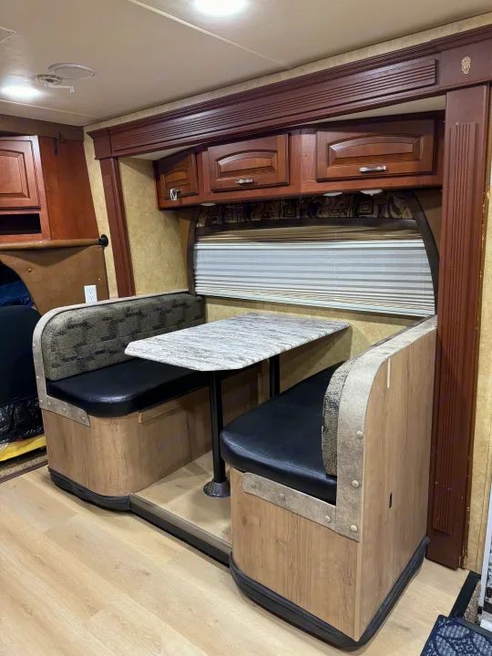 This RV rental dinette features comfortable booth seating, a table, and overhead cabinets, creating a functional dining area.. Jayco Melbourne 2012