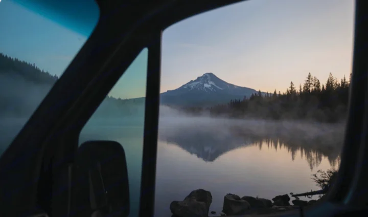 Your RV rental view: a serene lake with misty reflections of a snow-capped mountain at dawn.. Mercedes Sprinter 2022