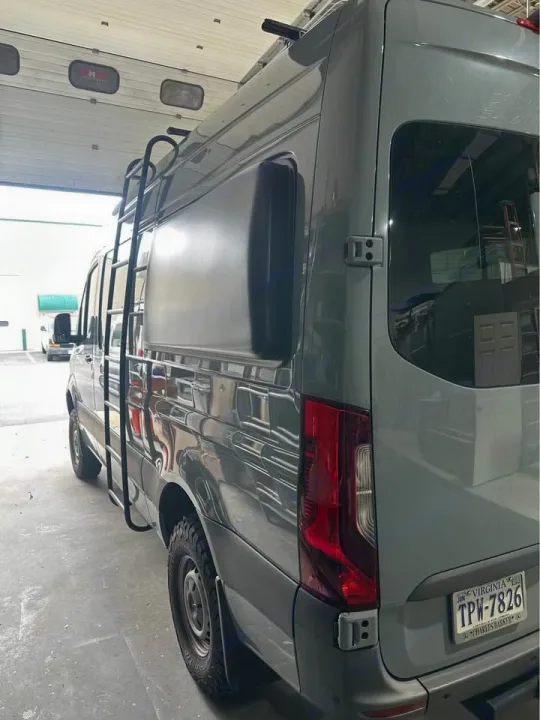 Grey Sprinter adventure van, equipped with a side ladder & rugged tires, ready for RV rental.. Mercedes Sprinter 2022
