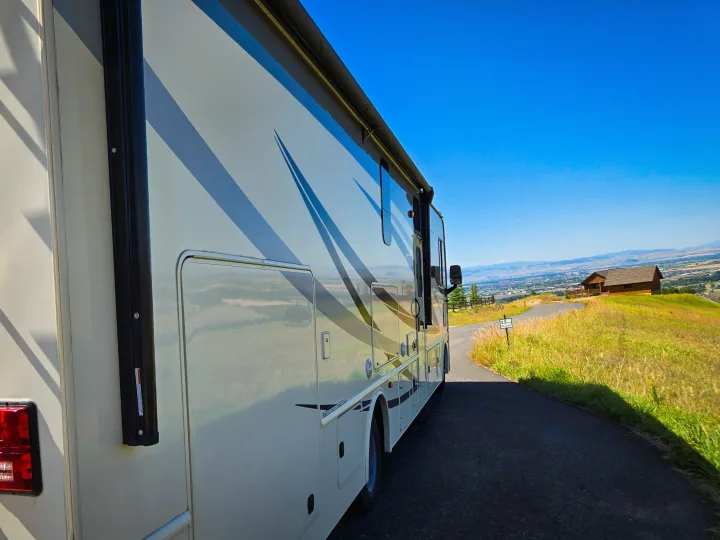 RV rental motorhome parked on a winding road, offering stunning valley views under a clear blue sky. Perfect for scenic travel.. Flair-Fleetwood Flair-Fleetwood Motorhome 2019