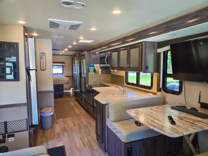Explore this modern RV rental interior with a fully equipped kitchen, cozy dinette, and comfortable bedroom space.. Flair-Fleetwood Flair-Fleetwood Motorhome 2019