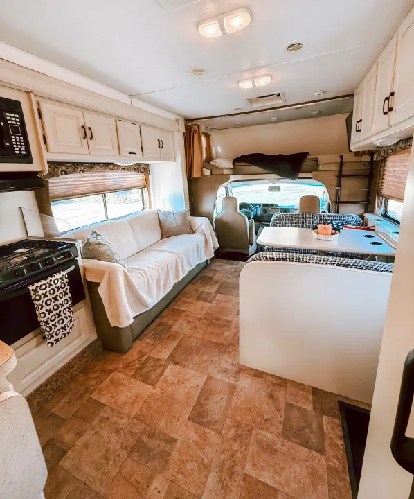 Bright RV rental interior with full kitchen, comfy sofa, and dinette. A complete and inviting mobile living space.. Forest River Sunseeker 2015