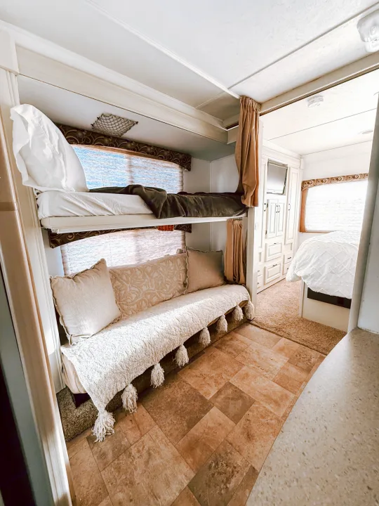 Inside a comfortable RV rental with bunk beds, a sofa, and a bright master suite. Relaxing travel space.. Forest River Sunseeker 2015