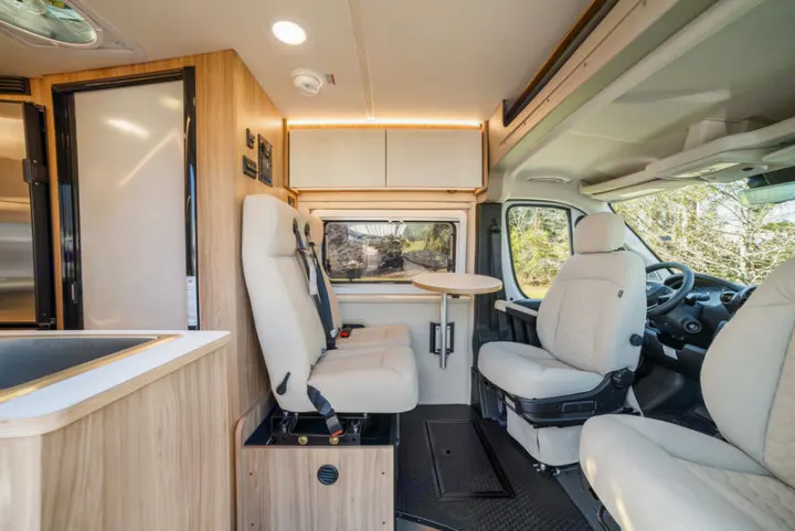Inside this modern rv rental, observe light wood cabinetry, comfy seating, a kitchen, and dining area. Ideal for travel!. Coachmen PIXEL 2026
