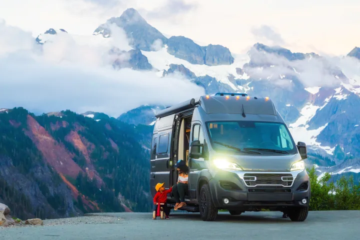 Mother and child bonding by their rv rental amidst stunning snow-capped mountains and a cloudy sky, showcasing adventure travel.. Coachmen PIXEL 2026