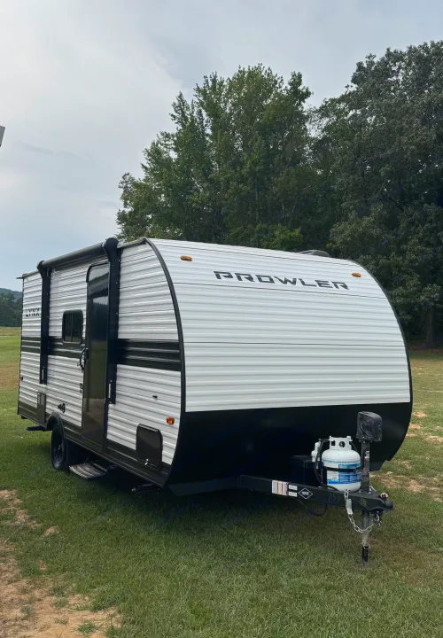 White & black Prowler travel trailer. Perfect RV rental for your adventure, with awning and propane tank.. Heartland Prowler Lynx 17BHX 2025