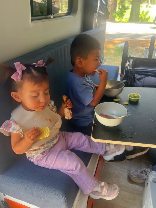 RV rental: Two kids eating chips, chicken, & fruit inside. Perfect family adventure meal.. Mercedes Sprinter 2021