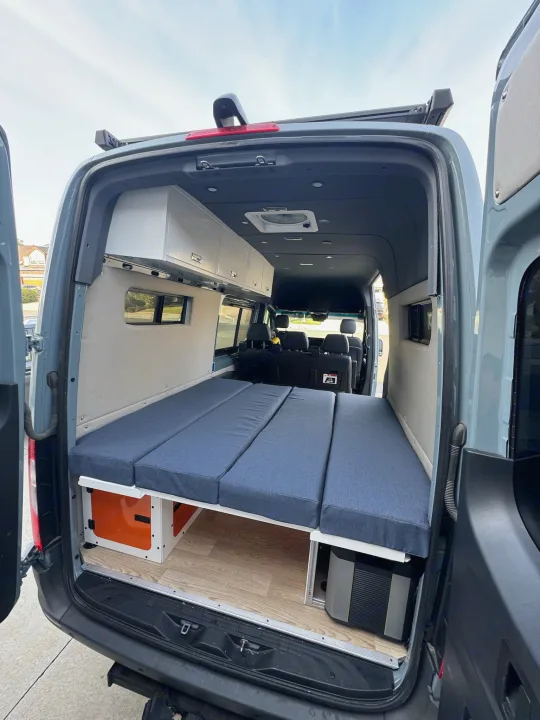 Spacious RV rental camper van interior with modular bed, overhead storage, and under-bed gear.. Mercedes Sprinter 2021