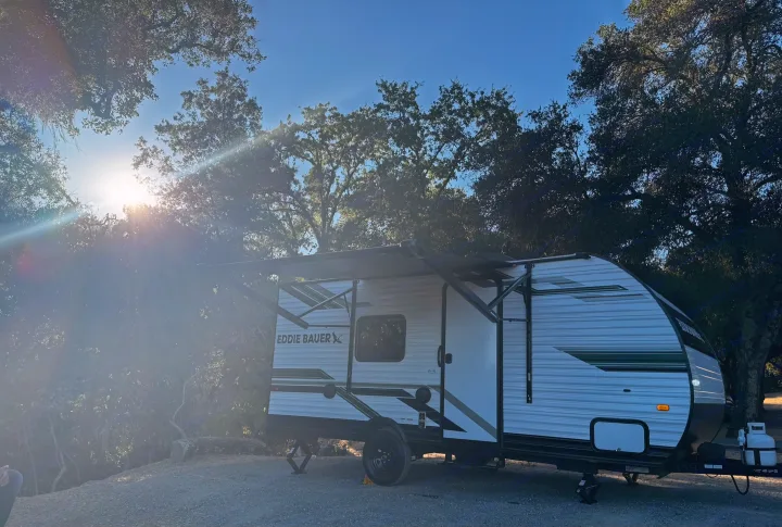 Our Eddie Bauer RV rental perfectly set for a relaxing camp adventure. Enjoying the golden hour light among the tall trees.. Heartland RVs Eddie Bauer Edition 17RB-C 2025