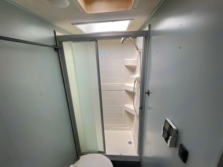 RV rental bathroom: A clean interior with a glass shower stall, toilet, and overhead skylight.. Thor Quantum 2018