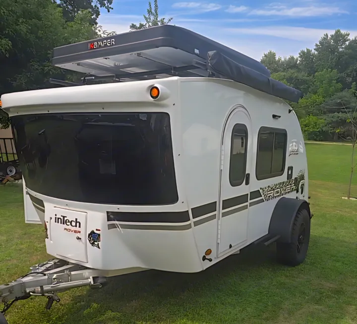 A white inTech Rover travel trailer with an iKamper rooftop tent, ideal for your next rv rental adventure or off-road camping.. InTech RV Luna 2023