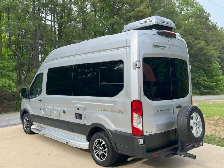 Side view of a silver Pleasure-Way camper van, a sleek RV rental option with a rear spare tire.. Pleasure-Way Pleasure-Way Class B 2023
