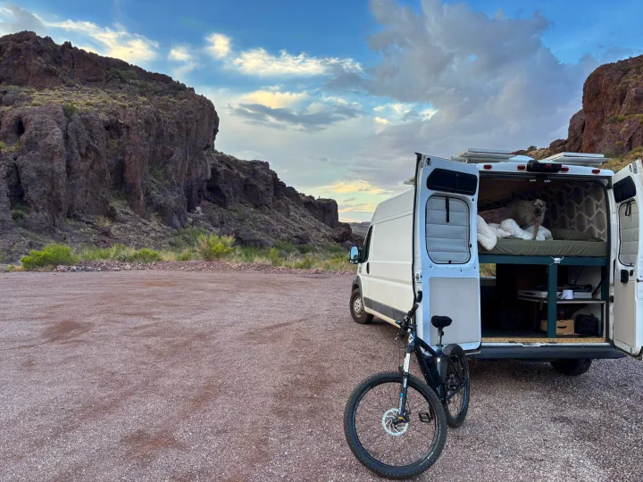 Adventure-ready RV rental setup with a dog, bike, and mountain views. Perfect for nature travel!. RAM Promaster 2500 2018