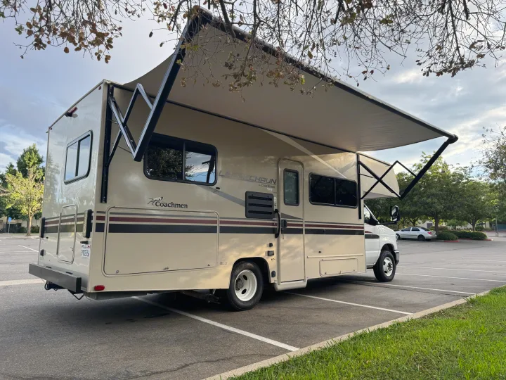 Class C Coachmen rv rental parked with awning extended. Perfect for your next travel adventure or camping trip.. Coachmen Leprechaun 23CB 2022