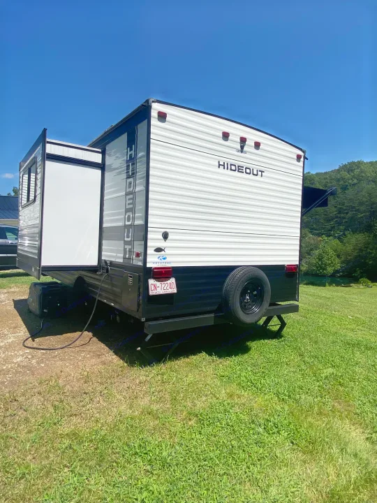 White & black Hideout RV rental with extended slide-out, powered by a generator, ready for your trip.. Keystone RV Hideout 2022